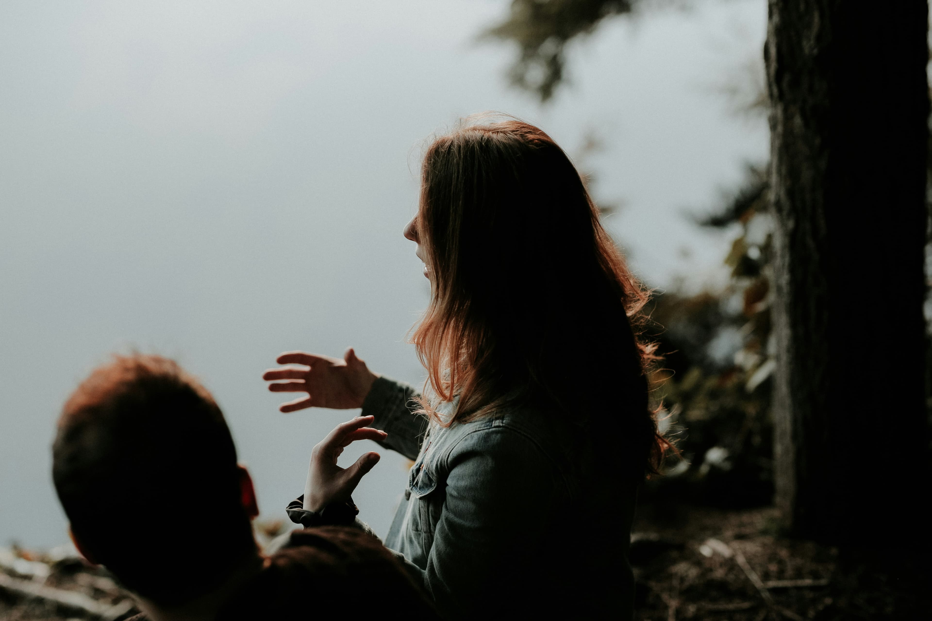 Two people holding coffee mugs in a quiet, intimate conversation